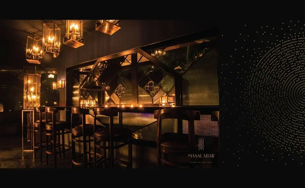 A black and gold bar with stools and lights.