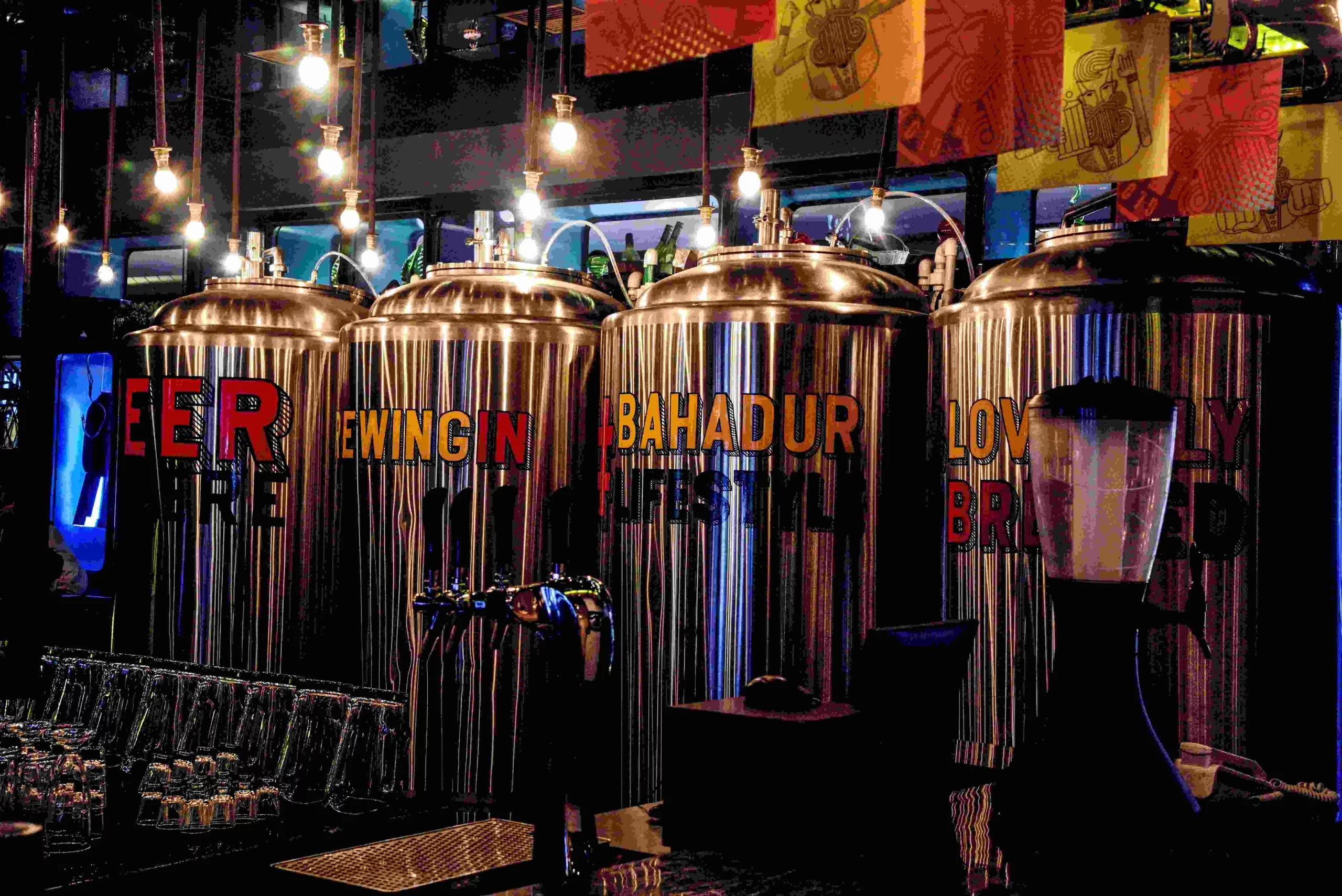 A row of beer kegs in a bar.