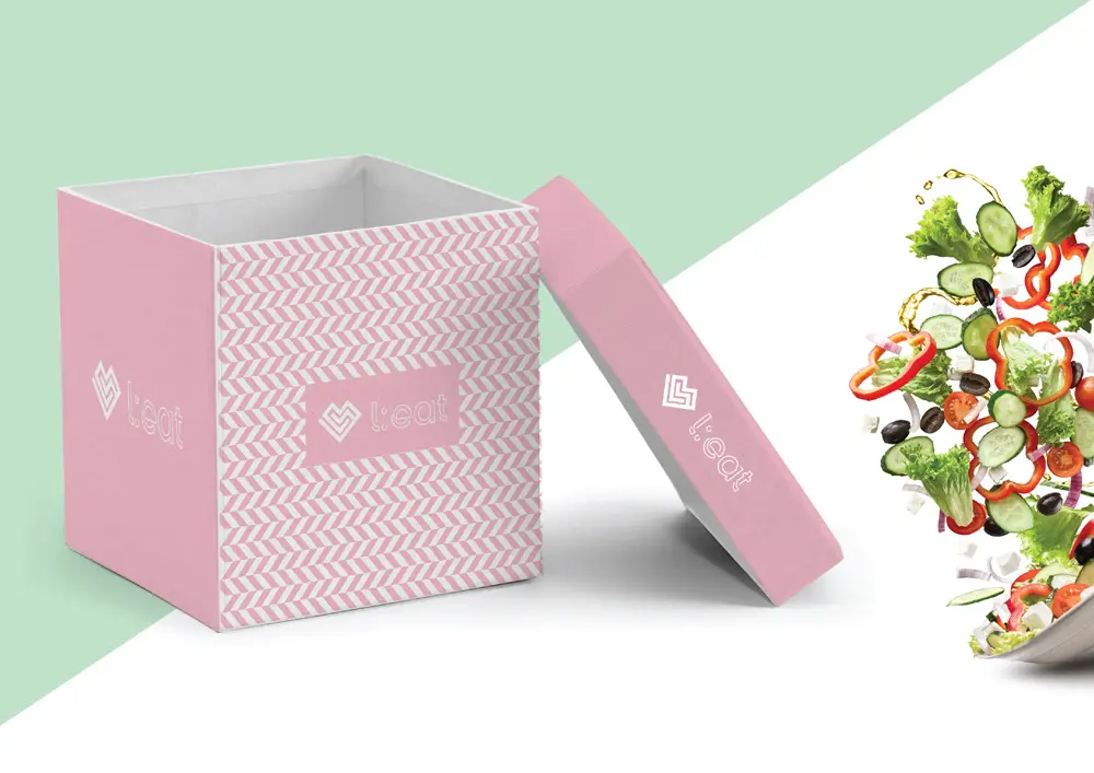 A pink box with a salad in it.