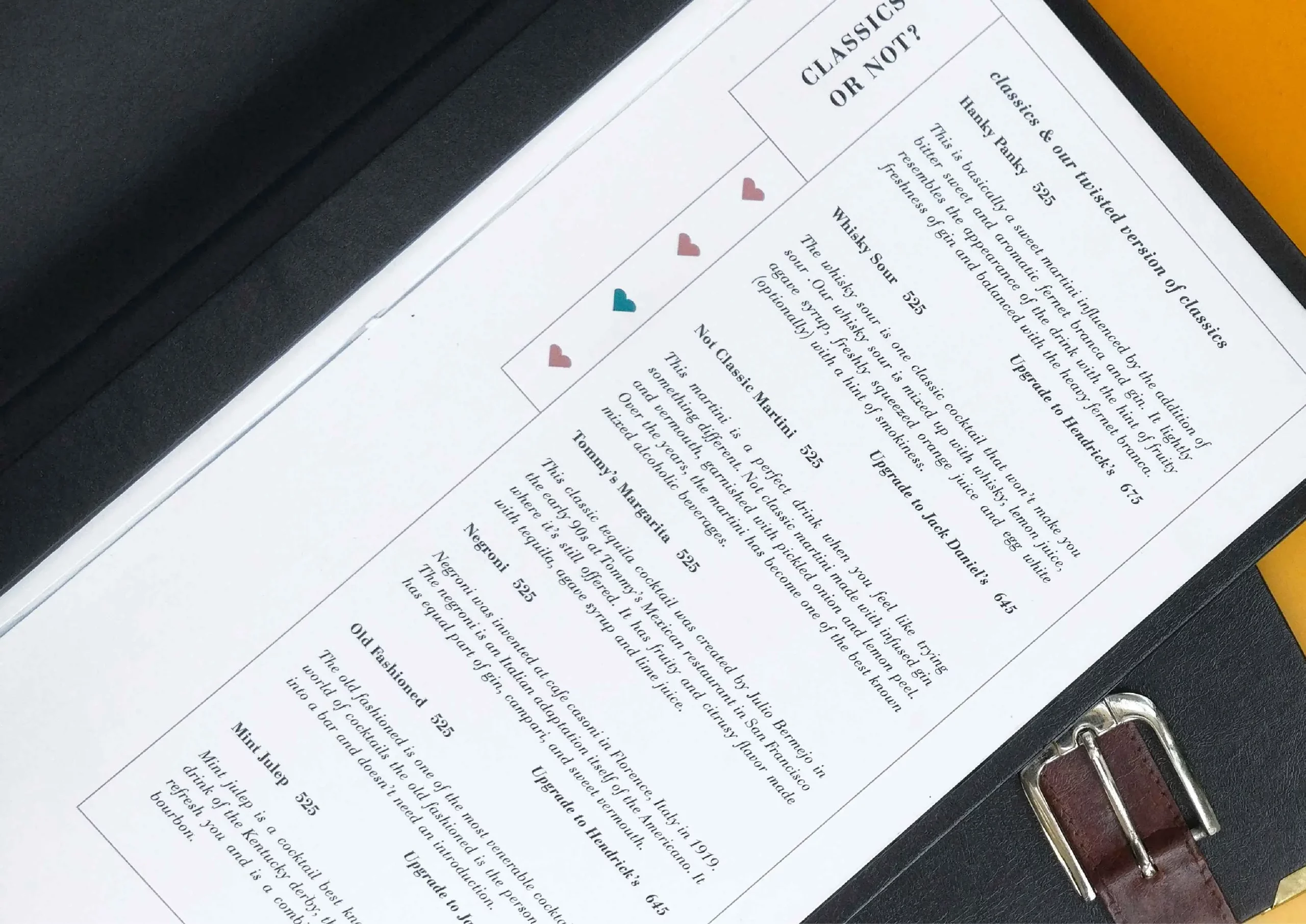 A black folder with a leather belt and a menu.