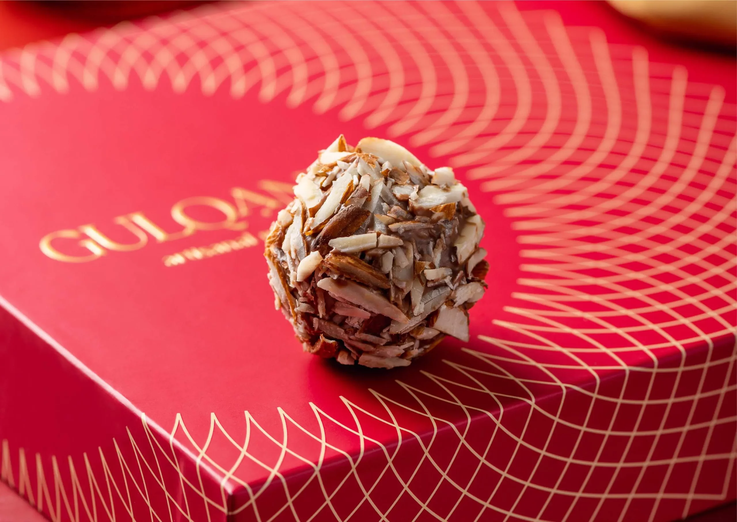 A chocolate ball sitting on top of a red box.