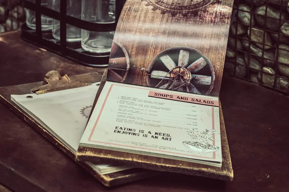 A menu is sitting on top of a wooden table.