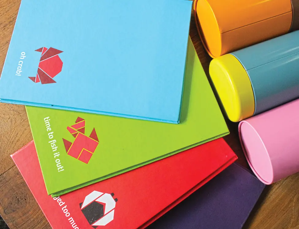 A set of colorful notebooks on a wooden table.