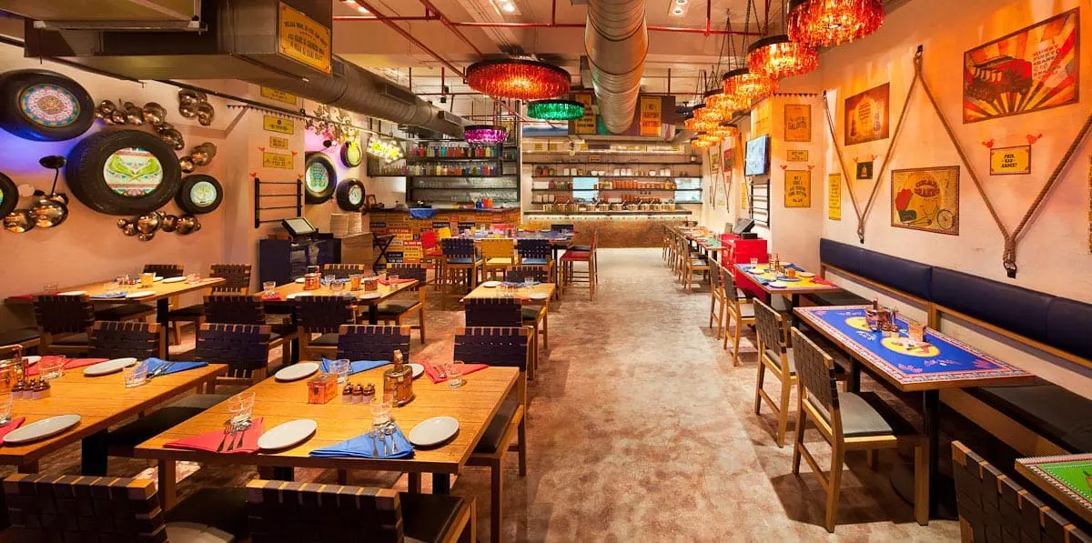The interior of a restaurant with colorful tables and chairs.