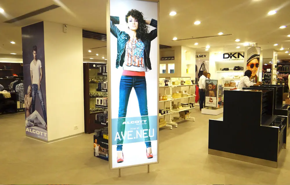 A woman is standing in a store with a poster.