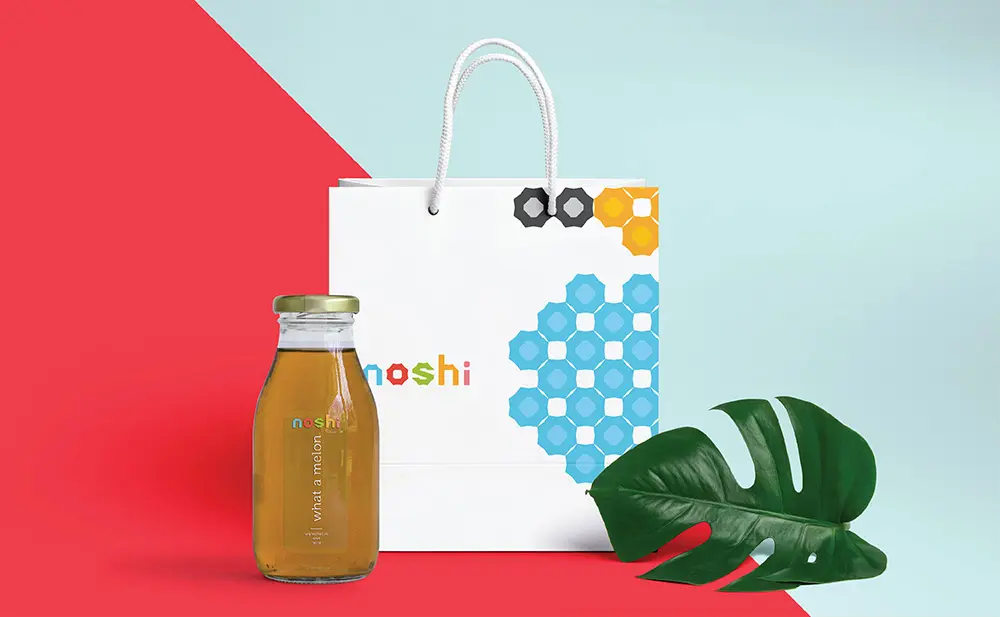 A shopping bag with a bottle of honey and a leaf.